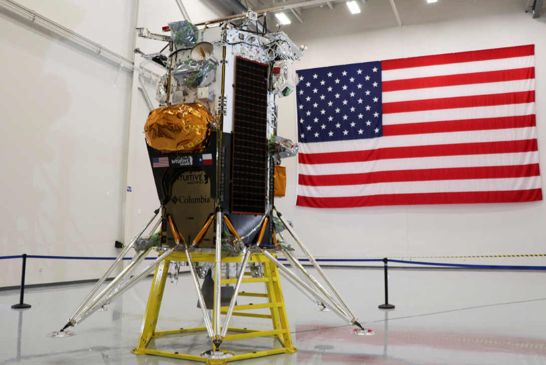 Módulo lunar da Intuitive Machines em exibição com a bandeira dos Estados Unidos ao fundo